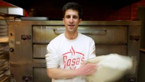Rosa's Fresh Pizza owner Mason Wartman, a former Wall Street equity researcher, makes a pizza in Philadelphia, Pennsylvania